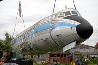 Fuselage suspended in the air with two cranes.